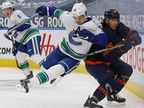 Vancouver Canucks forward Elias Peterson (40) throws a check against Edmonton Oilers defenseman Ethan Bear (74) during the second period at Rogers Place.