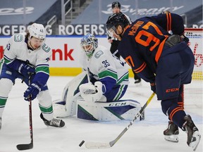 Vancouver Canucks defencemen Quinn Hughes (43) tries to knock a puck away from Edmonton Oilers forward Connor McDavid (97) during the first period at Rogers Place.