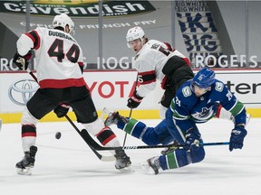 Vancouver Canucks forward Brandon Sutter scores the first of his three goals, this in the first period, while Ottawa Senators defencemen Erik Gudbranson and Mike Reilly look on at Rogers Arena on Jan. 25, 2021.