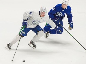 Nils Hoglanders tries to get by Elias Pettersson in a scrimmage game at Rogers Arena on Wednesday.