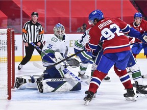 The Vancouver Canucks' team defence is making things very difficult for its goalies. (Pictured is Jonathan Drouin controlling the puck in front of Thatcher Demko on Tuesday night.)