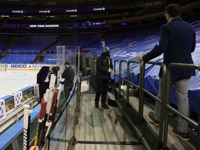 Due to updated COVID-19 protocols, the glass at New York’s Madison Square Garden was removed from behind the team benches last week as workers took measurements for additional safety measures prior to a Rangers-Washington Capitals game.