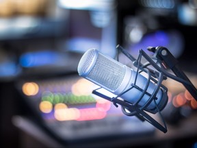 Microphone in a professional recording or radio studio, equipment in the blurry background