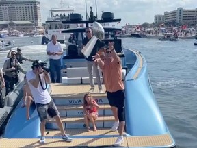 Tampa Bay Buccaneers quarterback Tom Brady throws the Lombardi trophy during a boat parade celebrating the team's Super Bowl victory February 10, 2021 in Tampa.