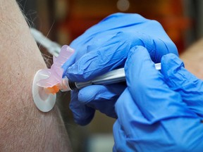 Pharmacist Carmine Pascarella administers a Moderna vaccine for local resident Geoff Corakhill inside a Walmart store in West Haven, Connecticut, February 17, 2021.