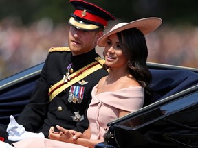 In this file photo taken on June 09, 2018 Britain's Prince Harry, Duke of Sussex and Britain's Meghan, Duchess of Sussex return in a horse-drawn carriage after attending the Queen's Birthday Parade, 'Trooping the Colour' on Horseguards parade in London.