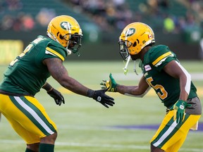 Running back Shaq Cooper (right) celebrates a play with Edmonton teammate C.J. Gable during an August 2019 Canadian Football League game in Edmonton. Cooper signed as a free agent with the B.C. Lions.