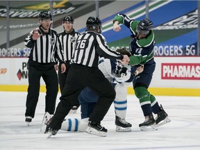 Winnipeg Jets defenceman Derek Forbort (24) fights with Vancouver Canucks forward Zack MacEwen (71) in the first period  at Rogers Arena.