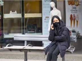 A woman waits at a bus stop in Vancouver in late January.