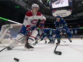 Corey Perry of the Montreal Canadiens picks up the loose puck while pressured by Tyler Myers of the Vancouver Canucks during their March 8 NHL game at Rogers Arena.