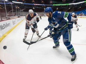 Canucks centre Brandon Sutter (right) battling for the puck against Jesse Puljujarvi of the Edmonton Oilers, has been coveted as a trade prospect for the last month by the Oilers, but Edmonton has its own salary-cap issues with which to deal.