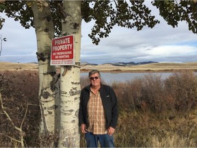 Rick McGowan with one of scores of questionable "No Trespassing" and 'Private property' sign on the giant Douglas Lake Ranch. Rick helped the Nicola Valley Fish and Game Club launch its suit. [PNG Merlin Archive]