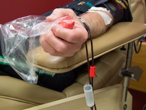 A blood donor donates blood in this file photo taken in Edmonton on July 3, 2015.