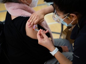 Maureen Kennedy, 78, receives the COVID-19 vaccine from a Vancouver Coastal Health worker.