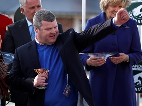 Trainer Gordon Elliott celebrates with a trophy after the 5.15 Randox Health Grand National Handicap Chase at the Aintree Racecourse in Liverpool, Britain, April 6, 2019.
