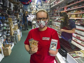 Stephanie Richardson, manager at Pastime Sports and Games in Langley, holds a Wayne Gretzky rookie card, Base Set Shadowless Charizard Pokemon card and an unopened Pokemon Fossil Pack from the mid-1990s.