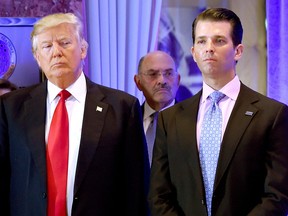 Donald Trump and his son Donald, Jr., arrive for a press conference at Trump Tower in New York, as Allen Weisselberg (middle), chief financial officer of The Trump, looks on.