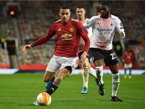 Manchester United striker Mason Greenwood (left) takes on AC Milan's Canada-born defender Fikayo Tomori during the UEFA Europa League round of 16 first leg match at Old Trafford on Thursday.