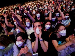 People wearing protective masks attend a concert of "Love of Lesbian" at the Palau Sant Jordi, the first massive concert since the beginning of the coronavirus disease (COVID-19) pandemic in Barcelona, Spain on March 27, 2021.