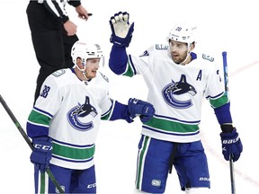 Vancouver Canucks defenceman Nate Schmidt (88) celebrates his first period goal with Vancouver Canucks centre Brandon Sutter (20) against the Winnipeg Jets at Bell MTS Place.