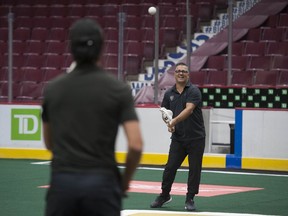 Warriors head coach Chris Gill throws with player Mitch Jones at Rogers Arena.