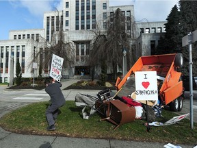 Strathcona resident Adam Levy dumps garbage from Strathcona Park at Vancouver City Hall on Feb. 24 to protest the continuing tent encampment at the park.