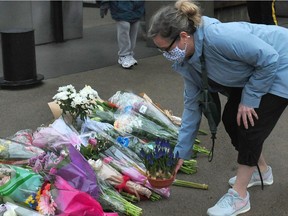 A woman lay flowers at the scene of a mass stabbing which left one person dead at the Lynn Valley Library.