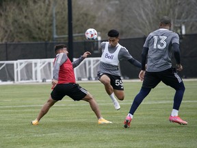 Vancouver Whitecaps midfielder Michael Baldisimo jumps past forward Lucas Cavillini during team training at UBC on Tuesday.