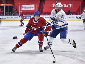 Jake Evans #71 of the Montreal Canadiens handles the puck against John Tavares #91 of the Toronto Maple Leafs during the third period at the Bell Centre on April 28, 2021 in Montreal, Canada.