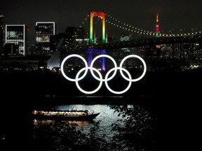 The Rainbow Bridge and Tokyo Tower are illuminated with Olympic colours to mark 100 days countdown to the Tokyo 2020 Olympics that have been postponed to 2021 due to the COVID-19 outbreak, in Tokyo, Japan, Wednesday, April 14, 2021.