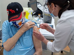 Louis Moro, 93, receives the Pfizer-BioNTech COVID-19 vaccine from Vena Anderson at a pharmacy prototype clinic in Halifax on March 9, 2021.