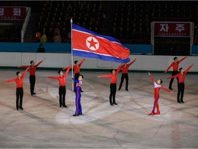 (FILES) In this file photo taken on February 15, 2019 Olympic ice skater Kim Ju Sik (centre L) of North Korea holds a national flag during the '26th Paektusan Prize Figure Skating Festival in Celebration of the Day of the Shining Star' as part of celebrations marking the birthday of late North Korean leader Kim Jong Il, in Pyongyang. - North Korea will not attend the forthcoming Olympic Games in Tokyo, Pyongyang's sports ministry said on April 6, 2021, citing the risks of coronavirus infection.