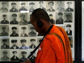 A Buddhist monk looks at pictures of victims of the Khmer Rouge regime at Tuol Sleng Genocide Museum in Phnom Penh, Cambodia June 1, 2016.