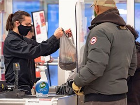 FILE PHOTO: A cashier wearing a mask to help slow the spread of coronavirus disease (COVID-19) bags groceries as the territory of Nunavut enters a two week mandatory restriction period in Iqaluit, Nunavut, Canada November 18, 2020.