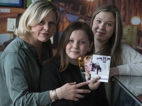 Daisy Barassi with daughters Celeste (centre), 11, and Giulia, 15, with photos of Barassi's grandfather Ernie Bodnar, a Canadian soldier serving in the Second World War, and mother Sherry.