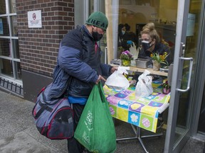Union Gospel Mission volunteer Virginia Whalen hands out Easter dinner to people at the mission in Vancouver’s Downtown Eastside on Saturday, April 3.