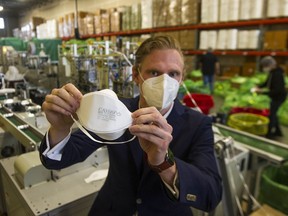 Vitacore Industries president Mikhail Moore show an N95 mask at his company’s Burnaby facility. ‘PPE is something that I was familiar with, even before the pandemic and just understanding contact precautions,’ he says.