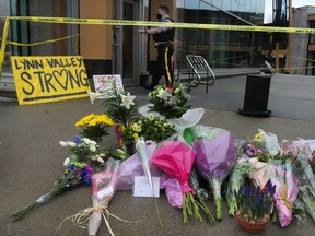 Local residents lay flowers at the scene the day after a mass stabbing that left one person dead at the Lynn Valley Library in North Vancouver
