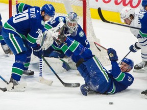 Vancouver Canucks goalie Braden Hotby, Brandon Sutter and Tyler Myers keep the puck out of their net against the Toronto Maple Leafs at Rogers Arena on Sunday.