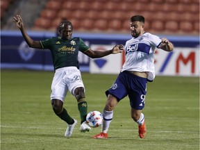 Portland Timbers midfielder Diego Chara (21) and Vancouver Whitecaps FC forward Lucas Cavallini (9) battle in the first half at Rio Tinto Stadium.