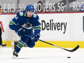 Quinn Hughes of the Vancouver Canucks skates with the puck during NHL action against the Edmonton Oilers at Rogers Arena on March 13, 2021.