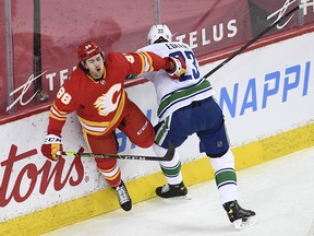 Calgary Flames forward Andrew Mangiapane collides with Vancouver Canucks defenceman Alexander Edler during the first period at Scotiabank Saddledome.