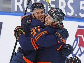 Oilers forward Connor McDavid celebrates his 100th point of the season on a goal by forward Leon Draisaitl against the Vancouver Canucks at Rogers Place in Edmonton Saturday.