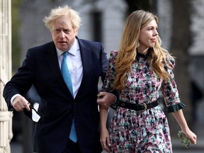 Britain's Prime Minister Boris Johnson and partner Carrie Symonds walk to Westminster polling station to vote, in London, May 6, 2021.