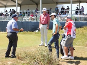 Joaquin Niemann of Chile speaks to a rules official near the 16th green during the first round of the 2021 PGA Championship at Kiawah Island Resort's Ocean Course in Kiawah Island, South Carolina, Thursday, May 20, 2021.