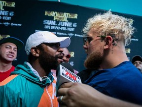 Floyd Mayweather (L) and Jake Paul pose during a press conference at Hard Rock Stadium, in Miami Gardens, Florida, on May 6, 2021.