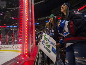 Fans celebrate a Vancouver Canucks goal against the Calgary Flames in the first period of a regular season NHL game at Rogers Arena on Feb. 9, 2019.