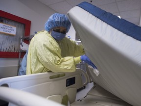 A member of the house-cleaning team disinfects a bed in the COVID-19 intensive care unit at St. Paul's Hospital in Vancouver on April 21, 2020.