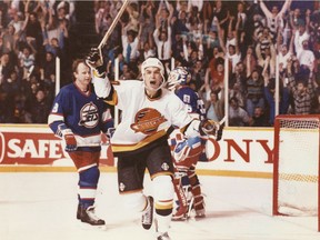 March 30, 1991. Vancouver Canucks forward Geoff Courtnall celebrates after scoring the winning goal in overtime against the Winnipeg Jets. Jets defenceman Randy Carlyle is in the background. [PNG Merlin Archive]