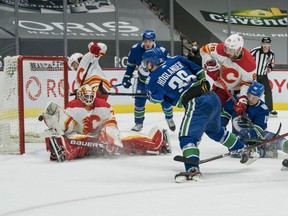 Canucks rookie Nils Höglander scores in the first period, his 13th goal of the season, on Flames netminder Louis Domingue on Tuesday at Rogers Arena.